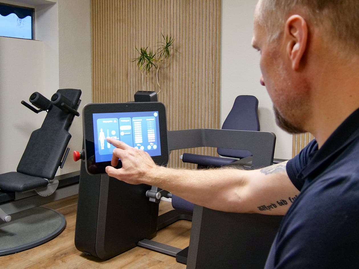 Trainer erklärt verschiedene Trainingsmodi an einem Gerät